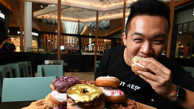 Phillip Kuoch sells a range of wacky doughnut creations at his Eastland pop-up store, including the 24K gold doughnut (centre). Picture: James Ross