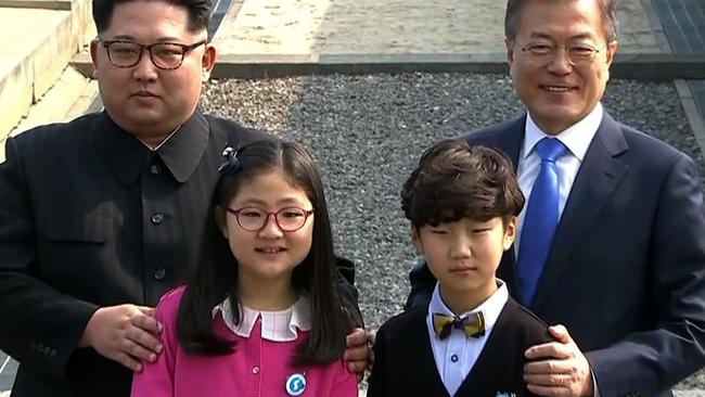 Kim Jong Un (L) and Moon Jae-in (R) posing with the two schoolchildren. Picture:  AFP.