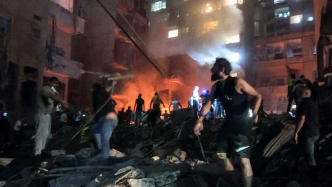 Lebanese civil defence members and other people inspect the site of an Israeli air strike on the Basta neighbourhood of Beirut. Picture: AFP.