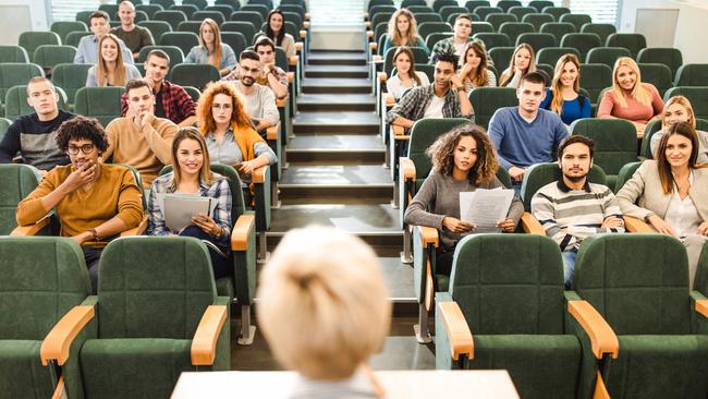 College students listening to their professor in a lecture hall.