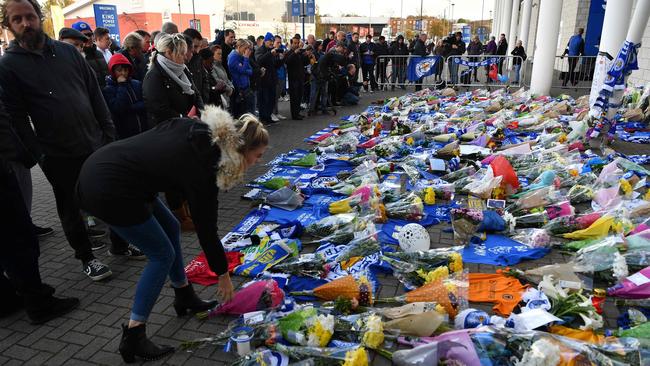 A woman adds flowers to a growing pile of tributes outside Leicester City Football Club's King Power Stadium. Picture: AFP