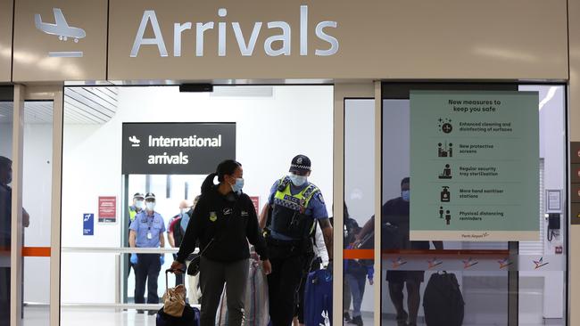 Passengers arrive at Perth Airport from Sydney, before being driven to a CBD hotel for quarantining on October 19. Picture: Getty Images