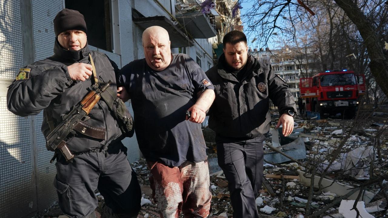 Ukrainian security forces accompany a wounded man out of the destroyed building. Picture: Wolfgang Schwan/Anadolu Agency via Getty Images