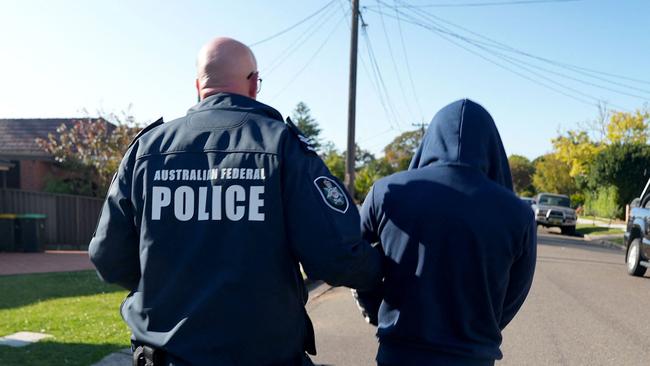 An Australian Federal Police officer arresting a suspect allegedly involved in an encrypted messaging app used by criminals worldwide to facilitate drug deals and order killings.