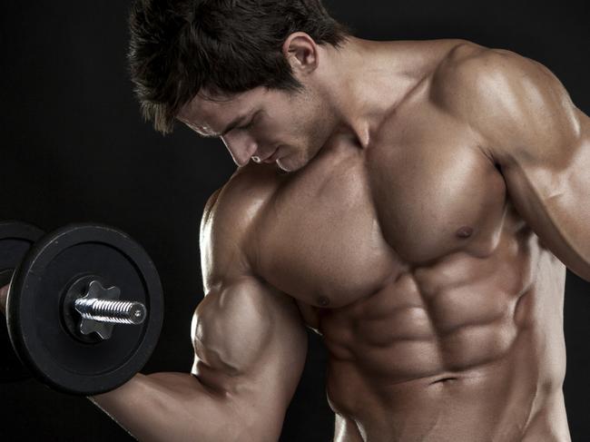 Muscular bodybuilder guy doing exercises with dumbbells