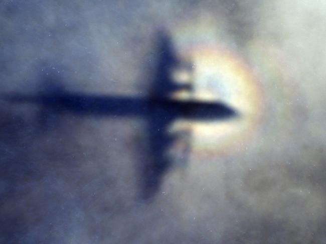 FILE - In this March 31, 2014 file photo, the shadow of a Royal New Zealand Air Force P3 Orion is seen on low level cloud while the aircraft searches for missing Malaysia Airlines Flight MH370 in the southern Indian Ocean, near the coast of Western Australia. The families of those onboard Malaysia Airlines Flight 370 said Monday, Nov. 21, 2016 they will mount a debris-hunting trip to Madagascar to search for clues to what happened to the missing plane. (AP Photo/Rob Griffith, File)