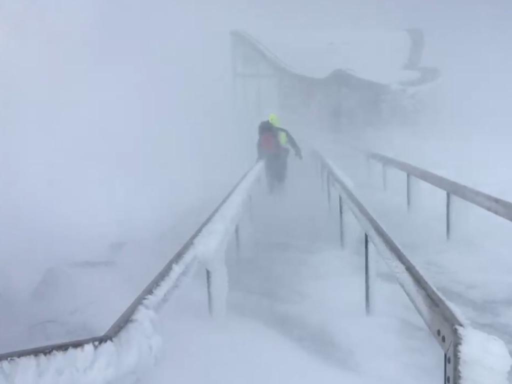 A Tasmania Police rescuer battles blizzard conditions at the top of Kunanyi/Mt Wellington during the rescue of eight people.