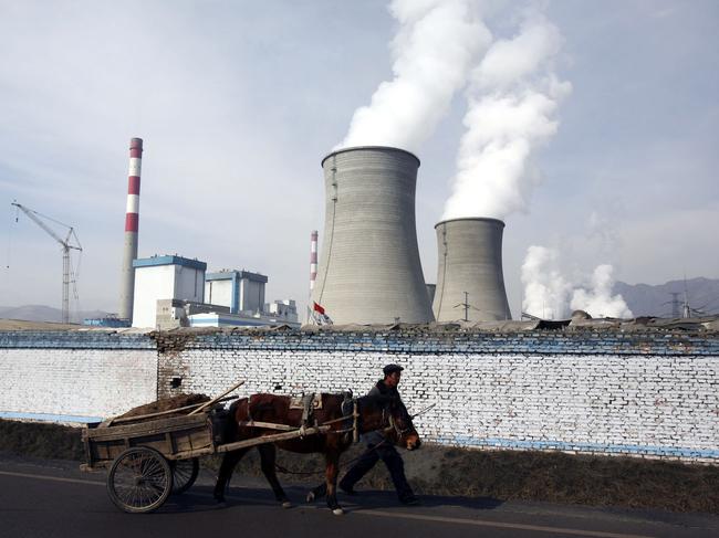 DATONG COUNTY, CHINA - JANUARY 31: (CHINA OUT) A farmer leads a cart walking past cooling towers of the coal-fired Datong County Thermal Power Plant on January 31, 2007 in Datong County of Qinghai Province, China. China has failed to make any headway with its efforts to protect the environment over the last three years as compared with other nations. A new government report ranks the country 100th on a list of 118 developing and developed countries in terms of "ecological modernization", the same ranking it held in 2004, according to the Modernization Report 2007 released by the Chinese Academy of Science. (Photo by China Photos/Getty Images)