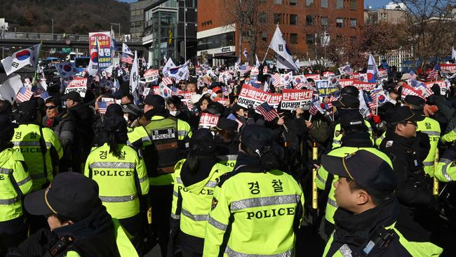 Police watch as supporters of impeached South Korea President Yoon Suk Yeol gather near the presidential residence in Seoul. Picture: AFP.