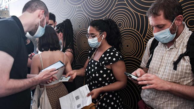 People show their health passes before entering a cinema in Paris on Wednesday. Picture: AFP