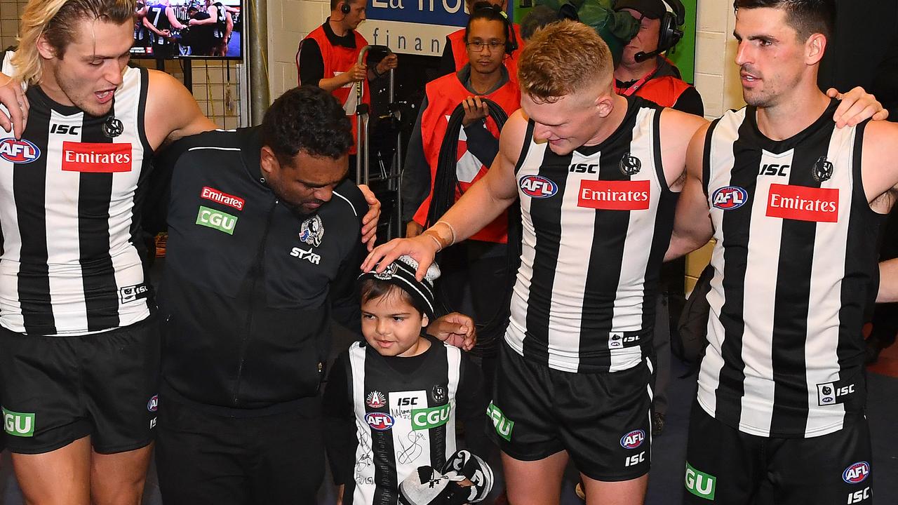 Kyron Maguire Senior and Kyron Maguire (centre) join the Magpies in the circle as they sing the song. Photo: Quinn Rooney/Getty Images