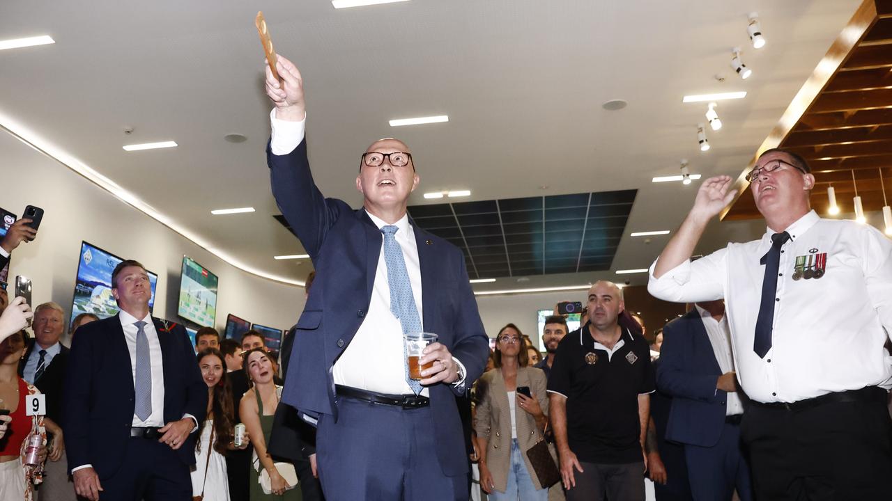 Peter Dutton tried his hand at two-up during an Anzac Day visit to the Townsville RSL. Picture: Richard Dobson / Newswire