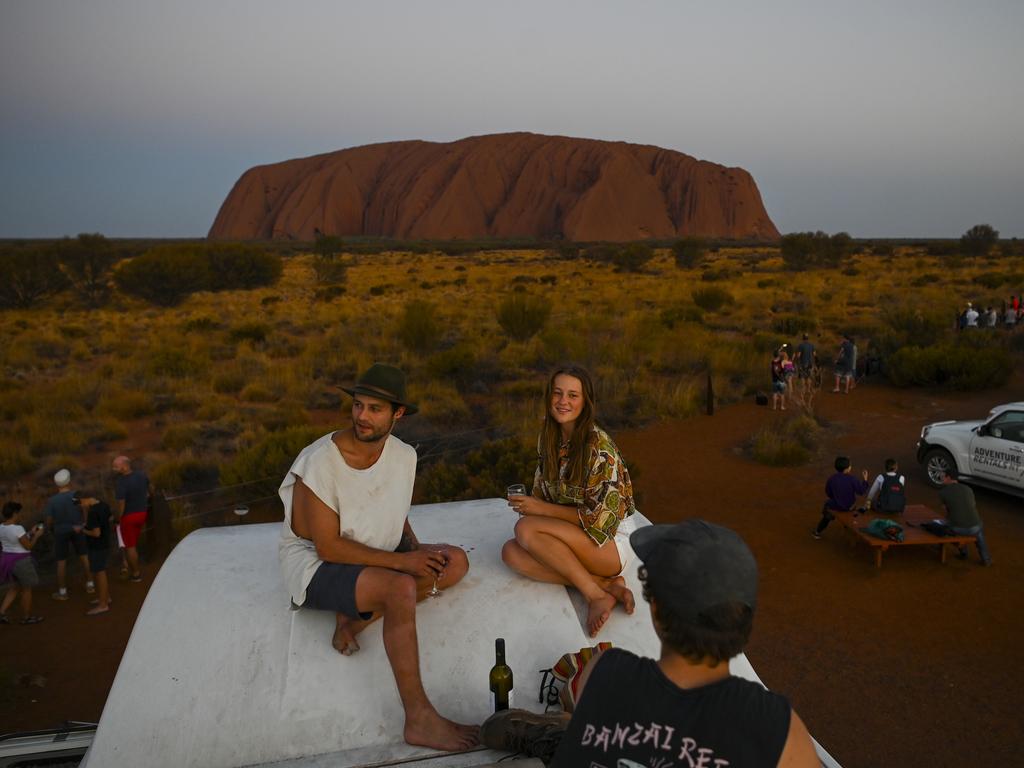 Sean Ruiper and Kristina Key observe Uluru from the top of their camper van during sunset at Uluru-Kata Tjuta National Park in the Northern Territory. Picture: AAP Image/Lukas Coch.