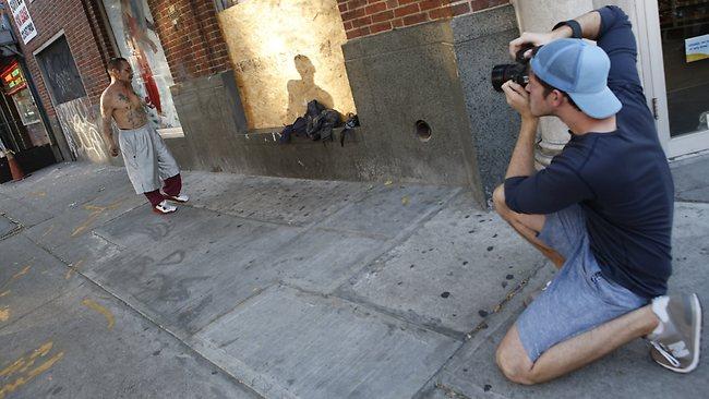 Photographer Brandon Stanton, right, creator of the Humans of New York blog, takes a portrait of Luis Torres in the East Village in New York. Picture: Kathy Willens