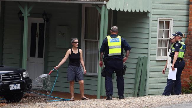 Police talk to Harrietville residents Haydn Richards and Sarah Draffen as the cool change sweeps through the Abbeyard fire system. Picture: Aaron Francis