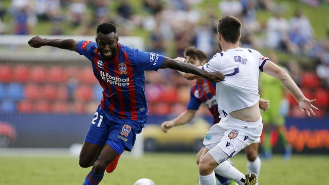 Bernie Ibini (left) battles with Perth’s Alex Grant during his time with the Newcastle Jets. Picture: AAP Image/Darren Pateman