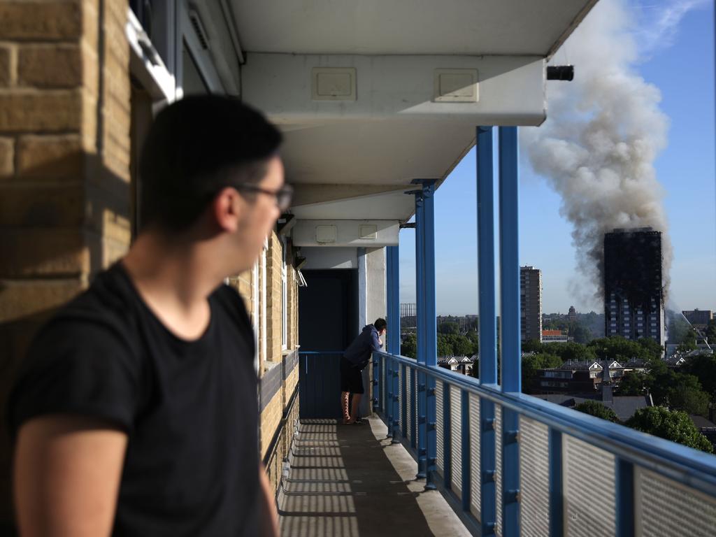 A resident of a nearby council estate watches smoke billowing from Grenfell Tower on June 14. Picture: AFP Photo/Daniel Leal-Olivas