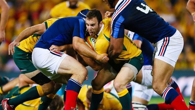 Australian halfback Nic White (C) is tackled by France's Damien Chouly (L) during the first rugby union test match at Suncorp Stadium in Brisbane on June 7, 2014. AFP PHOTO / PATRICK HAMILTON --- IMAGE RESTRICTED TO EDITORIAL USE - STRICTLY NO COMMERCIAL USE