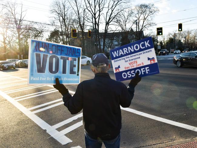 A volunteer holds signs during the Senate runoff elections in Georgia. Picture: AFP