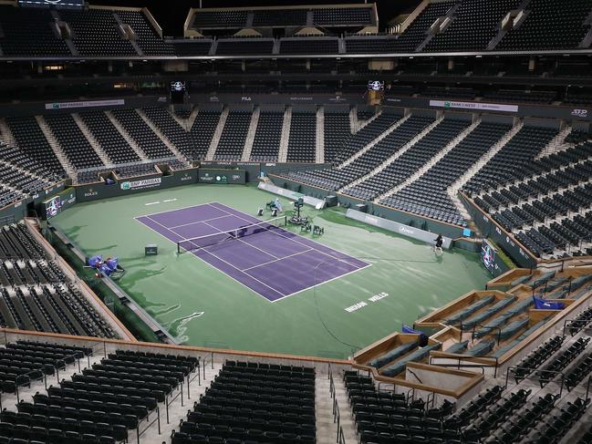 INDIAN WELLS, CALIFORNIA - MARCH 08: Courtmaster Jeffrey Brooker cleans the center court at the Indian Wells Tennis Garden on March 08, 2020 in Indian Wells, California. The BNP Paribas Open was cancelled by the Riverside County Public Health Department, as county officials declared a public health emergency when a case of coronavirus (COVID-19) was confirmed in the area.   Al Bello/Getty Images/AFP == FOR NEWSPAPERS, INTERNET, TELCOS & TELEVISION USE ONLY ==