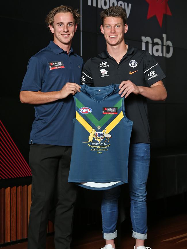 Jackson Mead (left) receives his AFL Academy guernsey from Carlton’s 2018 No. 1 draft pick Sam Walsh. Picture: Michael Dodge/Getty