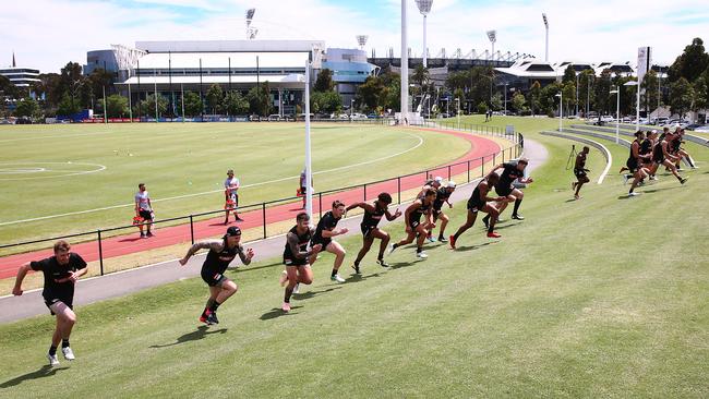 Magpies players sprint up a hill.