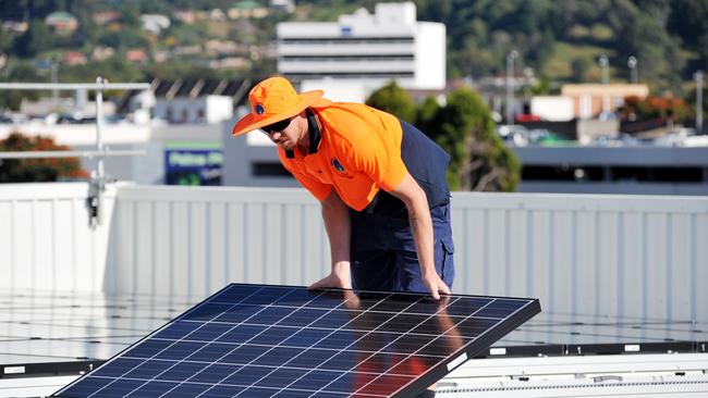 Ben Bulanyi installs solar panels on the roof of Rigby House for Coffs Harbour City Council. Photo: Bruce Thomas