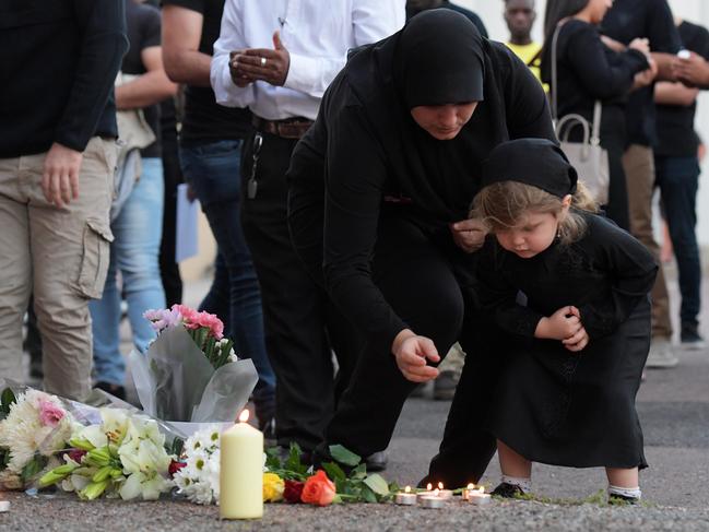 Mourners pay their respects to slain Darwin taxi driver Hassan Baydoun at the Palms Motel on Thursday night. Picture: Keri Megelus