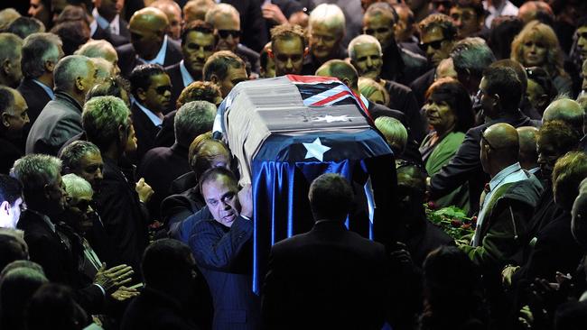 Mourners reach out to touch the coffin of Lionel Rose as it is carried through Festival Hall in Melbourne in 2011