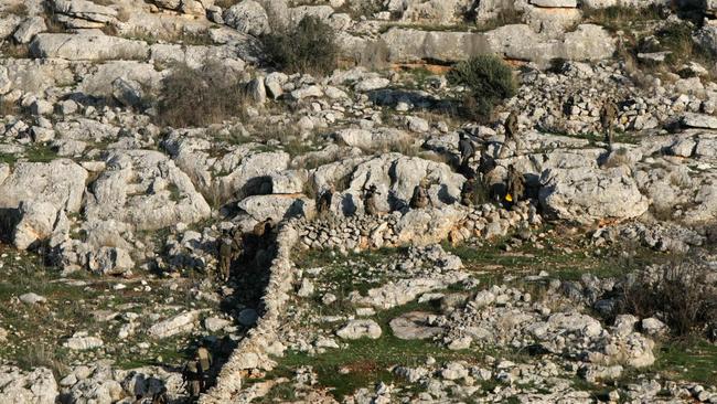 Anti-government fighters take a position near the northern Syrian town of Tal Rifaat.