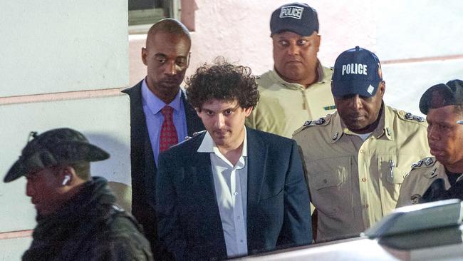 FTX founder Sam Bankman-Fried is led away handcuffed by officers of the Royal Bahamas Police Force in Nassau, Bahamas on December 13. (Photo by Mario Duncanson / AFP)