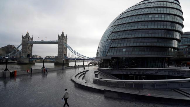 Pedestrians walk along the Thames river embankment near the Tower Bridge in central London during the third national lockdown. Picture: AFP