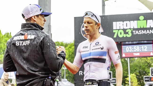 Australian triathlete Mitch Kibby comes second in the Ironman 70.3 Tasmania in Hobart on Sunday 4th February 2024 and is congratulated by race director, Carl Smith. Picture: Linda Higginson