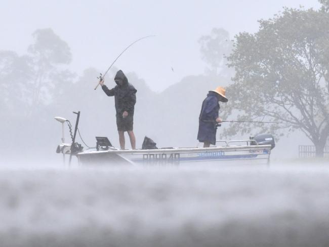 Wet weather in Townsville. Heavy rain does not stop fishing at Applins Weir. Picture: Evan Morgan