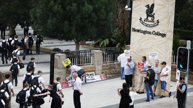 Parents with placards hold a silent protest as students arrive at the college. Picture: Richard Dobson