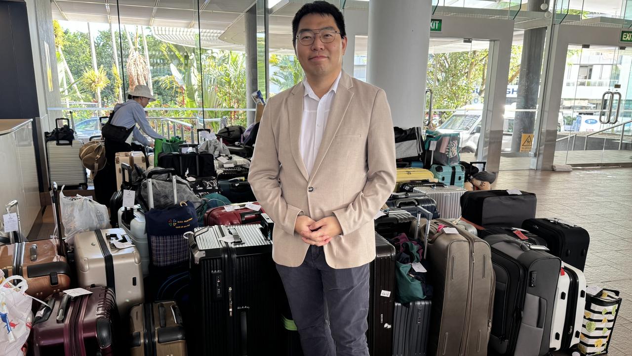 Hilton Cairns duty manager Alvin Kwok in front a large collection of luggage from guests who had evacuated sister hotel DoubleTree by Hilton following a helicopter crash on Monday, August 12. Picture: Arun Singh Mann