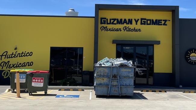 Guzman y Gomez’s Willows store had a skip bin out the front, loaded with dumped material. Picture: Leighton Smith.