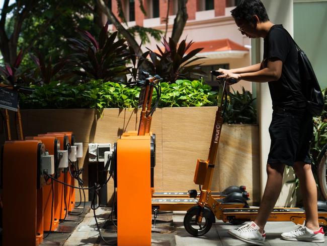 A man collects a Neuron Mobility electric scooter from a parking station in Singapore. The company has been approved to operate in Brisbane. Picture: Nicky Loh/Bloomberg News