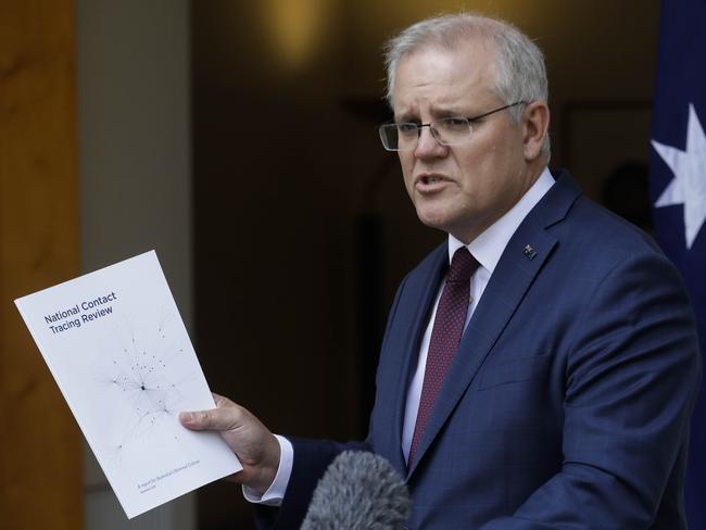 Mr Morrison holding a copy of the National Contract Tracing Review. Picture: Sean Davey