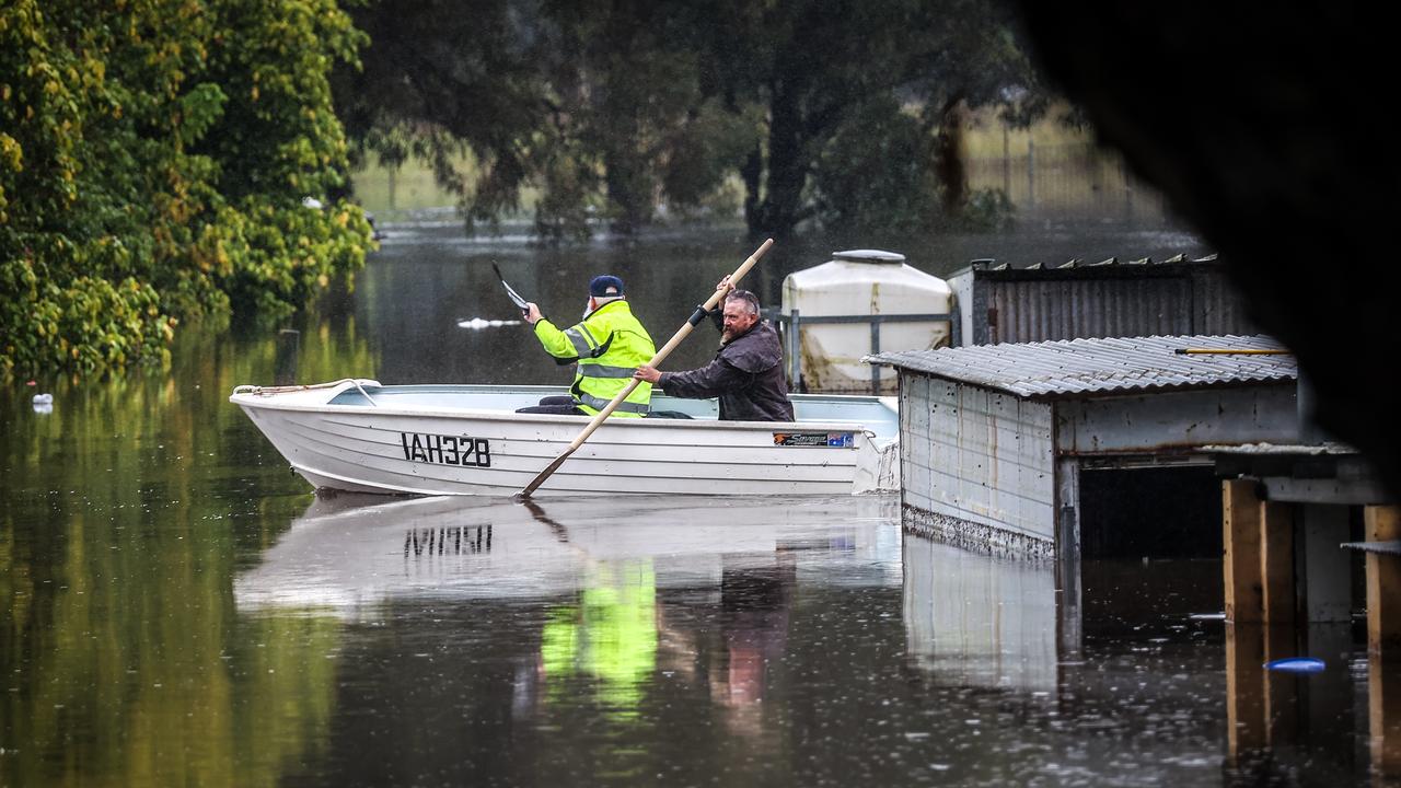 Locals row a boat past submerged homes in Windsor. Picture: Getty Images