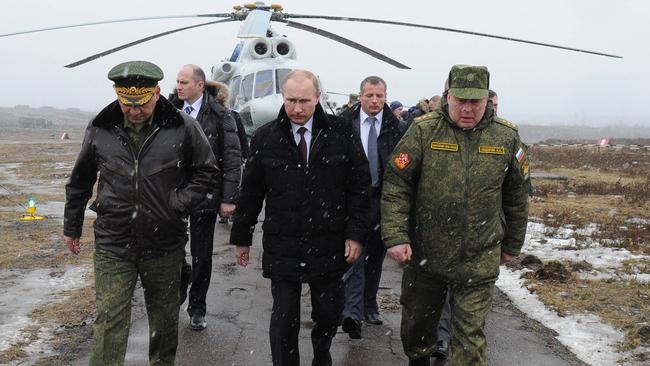 Vladimir Putin (centre) and Defence Minister Sergei Shoigu (left) walk to watch military exercises in the Leningrad region in 2014. Picture: AFP