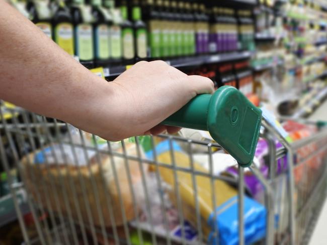 Woman hands pushing a shopping trolley in a supermarket.