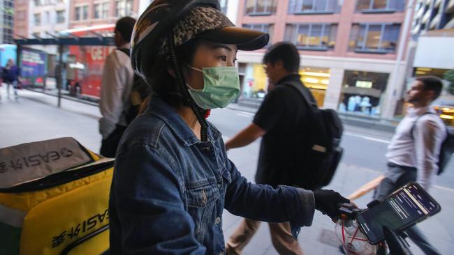 A food delivery rider wears a face mask in Sydney’s CBD on Monday. Picture: AAP