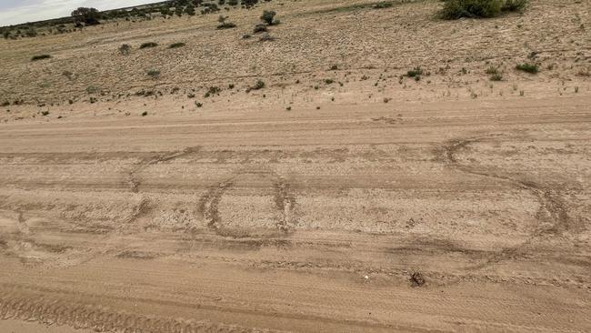 The pair scratched this SOS sign in the dirt, and even left a handwritten notes, before they were found near Innamincka.