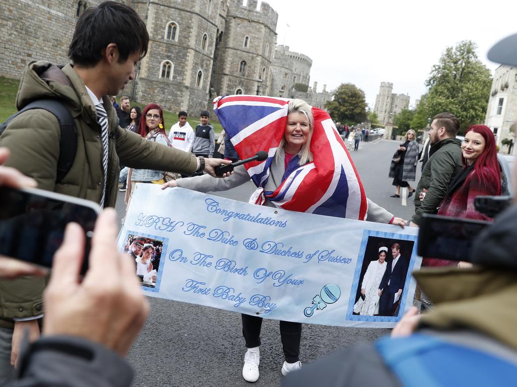 Thrilled fans dance through the streets of Windsor after the news the Duke and Duchess of Sussex have welcomed their first child. Picture: AP Photo/Alastair Grant