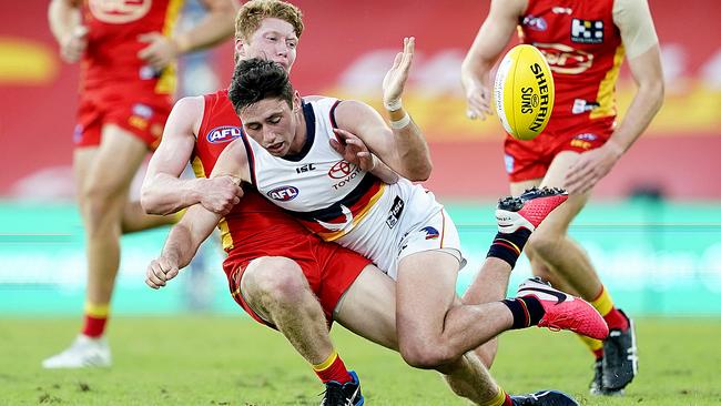 Matthew Rowell of the Suns tackles Chayce Jones of the Crows. Picture: AAP / Dave Hunt