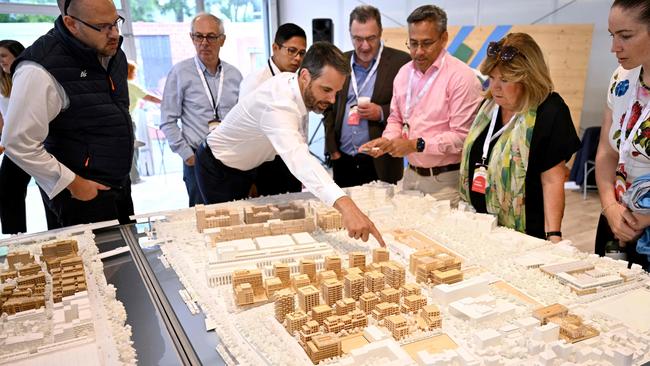 Members of International Olympic Committee (IOC) coordination commission look at a model of the 2024 Olympic and Paralympic Games athletes' village. Picture: Emmanuel Dunand / AFP