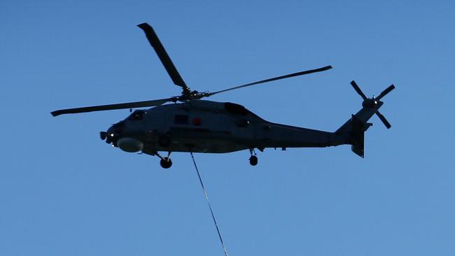 Pictured is a flypast by a Australian Navy Seahawk Helicopter flying a large International Fleet Review flag, accompanied by a Squirrel helicopter in International Fleet Review livery over Sydney Harbour today.