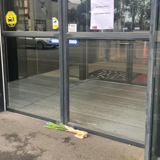 People have honoured the man who died with flowers at the entrance of the building. Picture: Facebook.