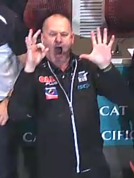 Screenshots of Port Adelaide coach Ken Hinkley celebrating Port Adelaide's win over Adelaide in Showdown 44. Hinkley is seen gesturing the numbers 0-5.